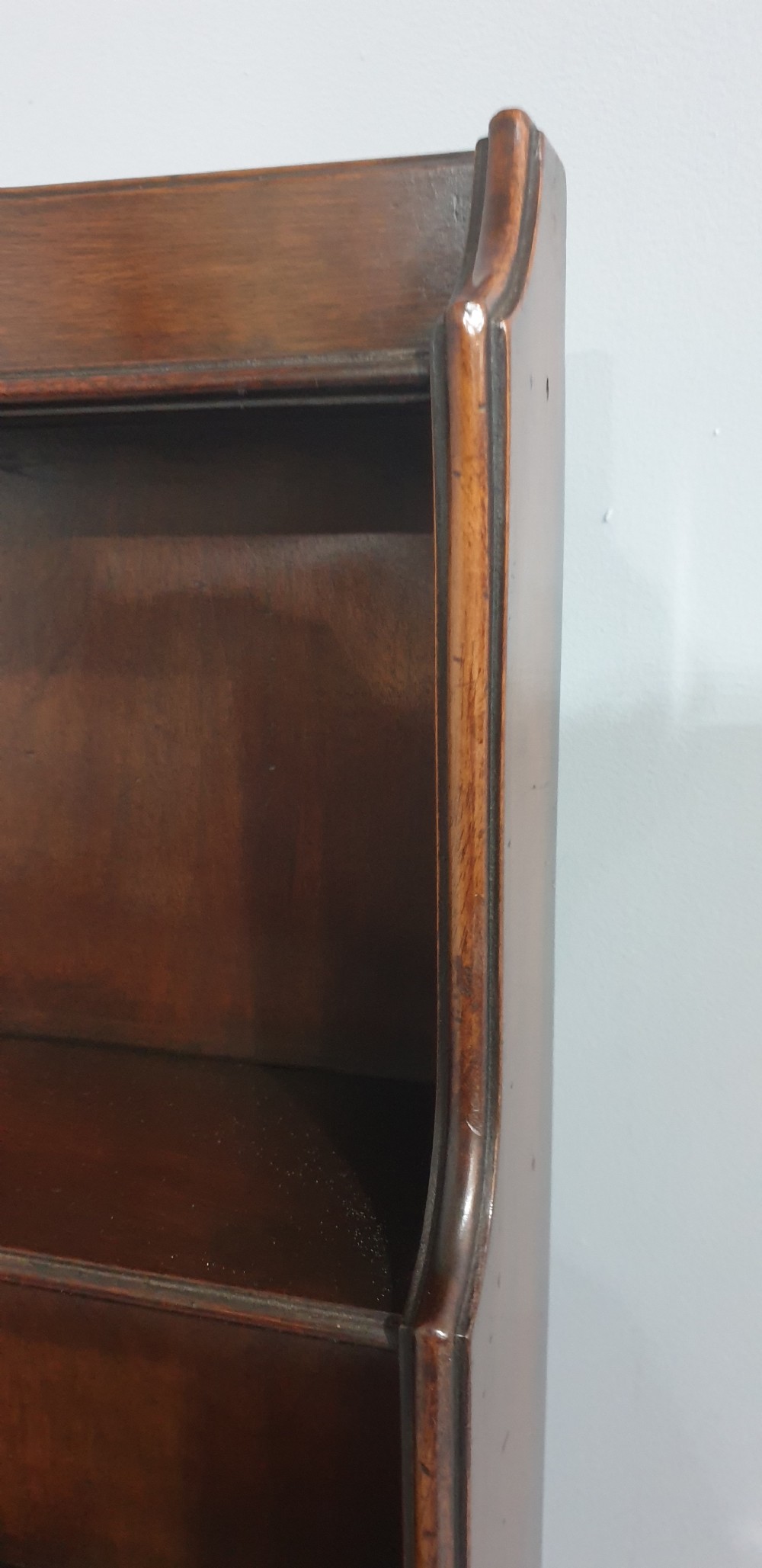 A tall, narrow mahogany cabinet featuring three open graduated shelves above a single drawer and a lower cupboard door with an oval flame mahogany inlay. View VIII