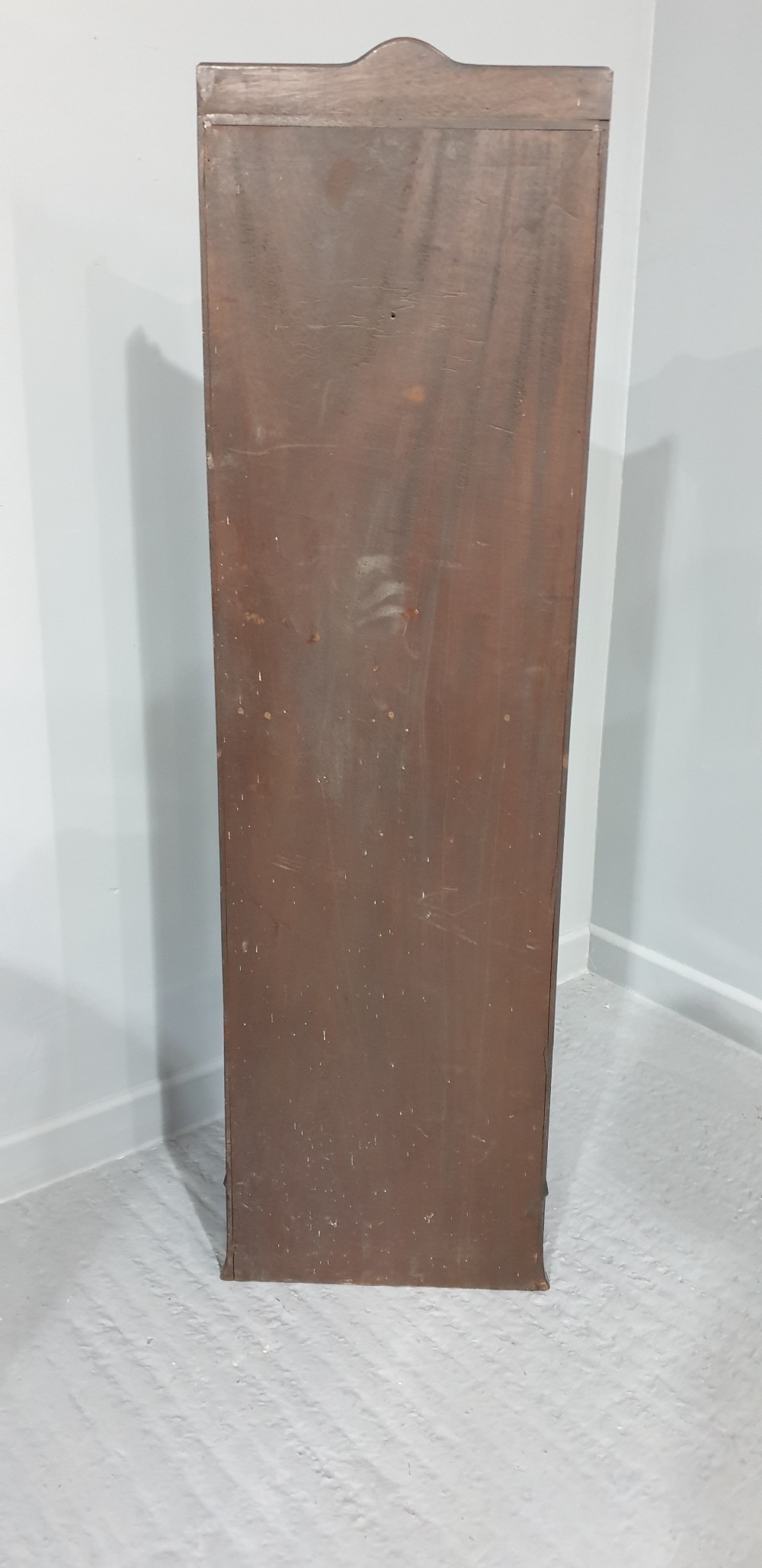 A tall, narrow mahogany cabinet featuring three open graduated shelves above a single drawer and a lower cupboard door with an oval flame mahogany inlay. View XIV
