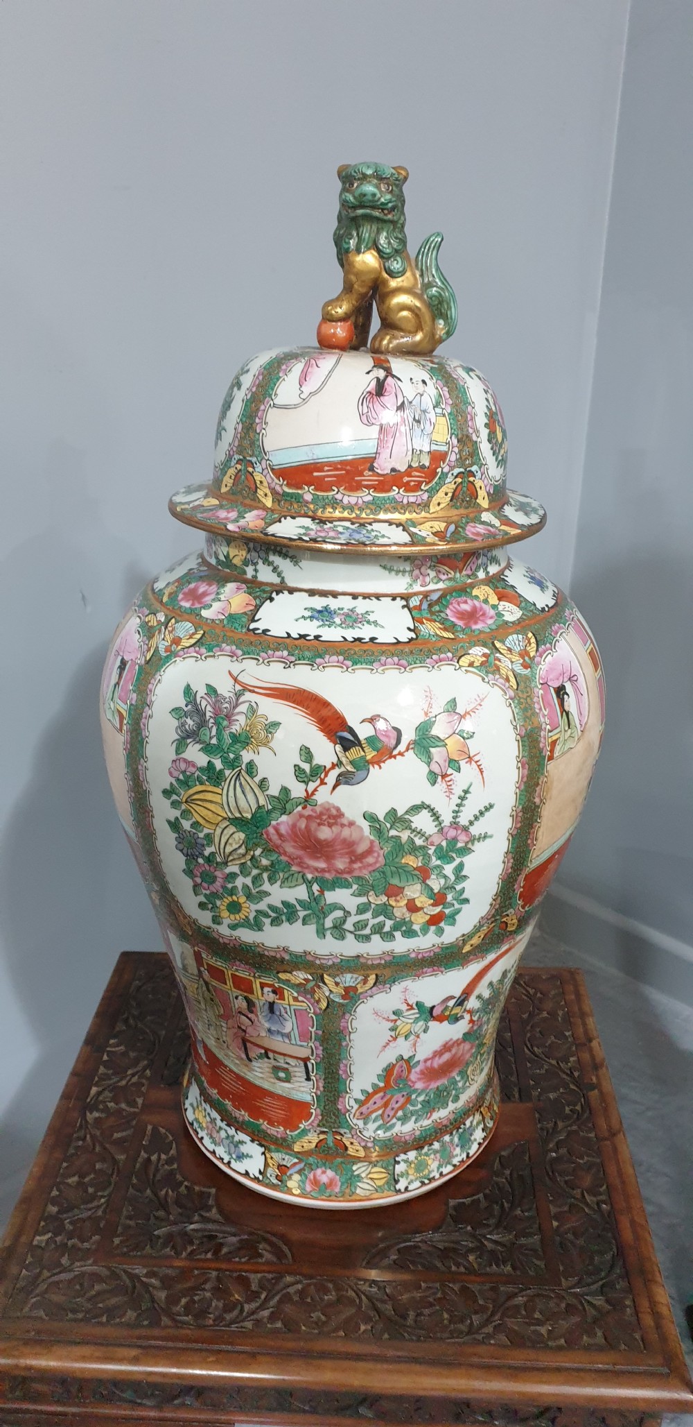 A pair of carved dark padouk wood low tables supporting large Cantonese famille rose porcelain temple jars topped with sculpted lion finials. View V