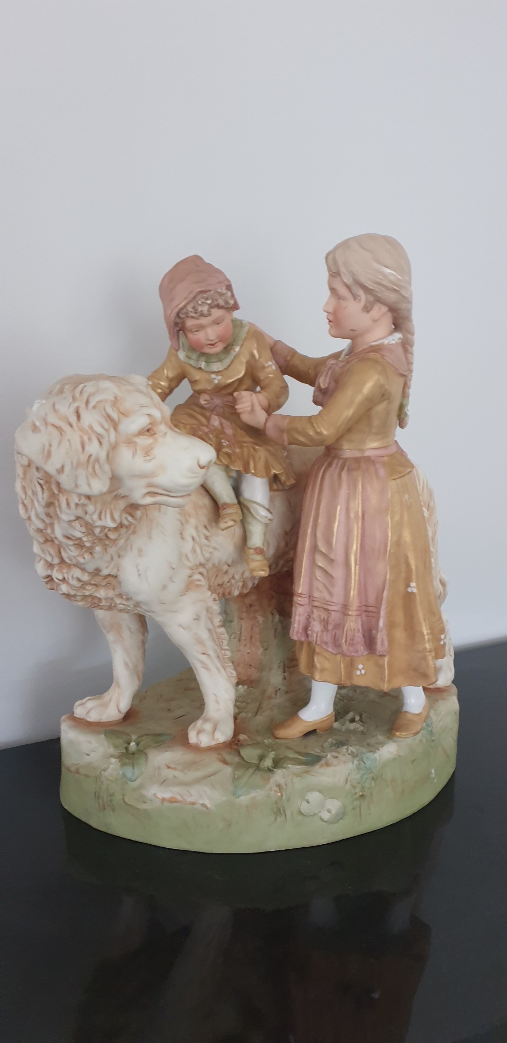 An antique Royal Dux porcelain figure group depicting two children interacting with a large dog on a green base. View II