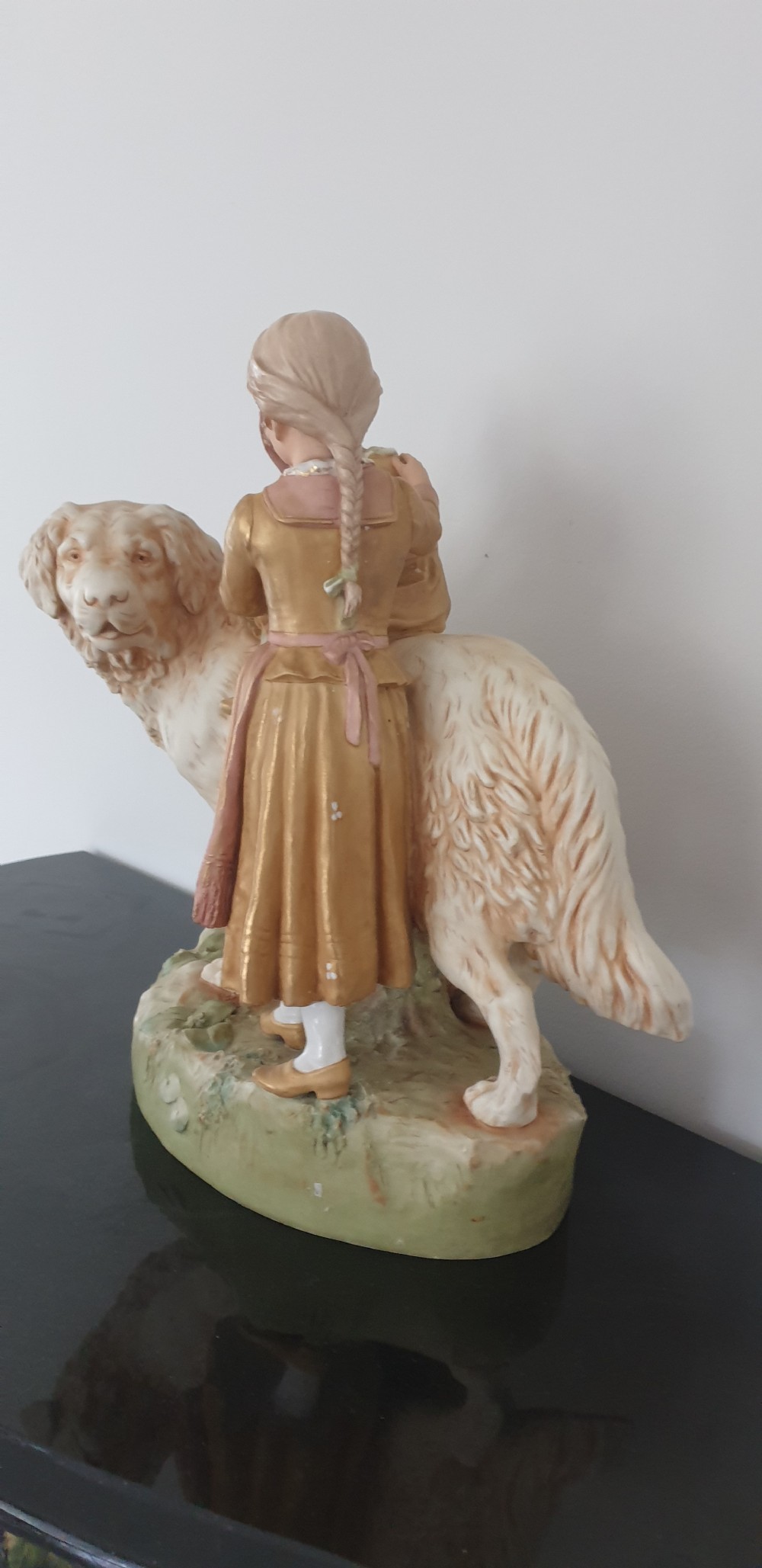 An antique Royal Dux porcelain figure group depicting two children interacting with a large dog on a green base. View IV