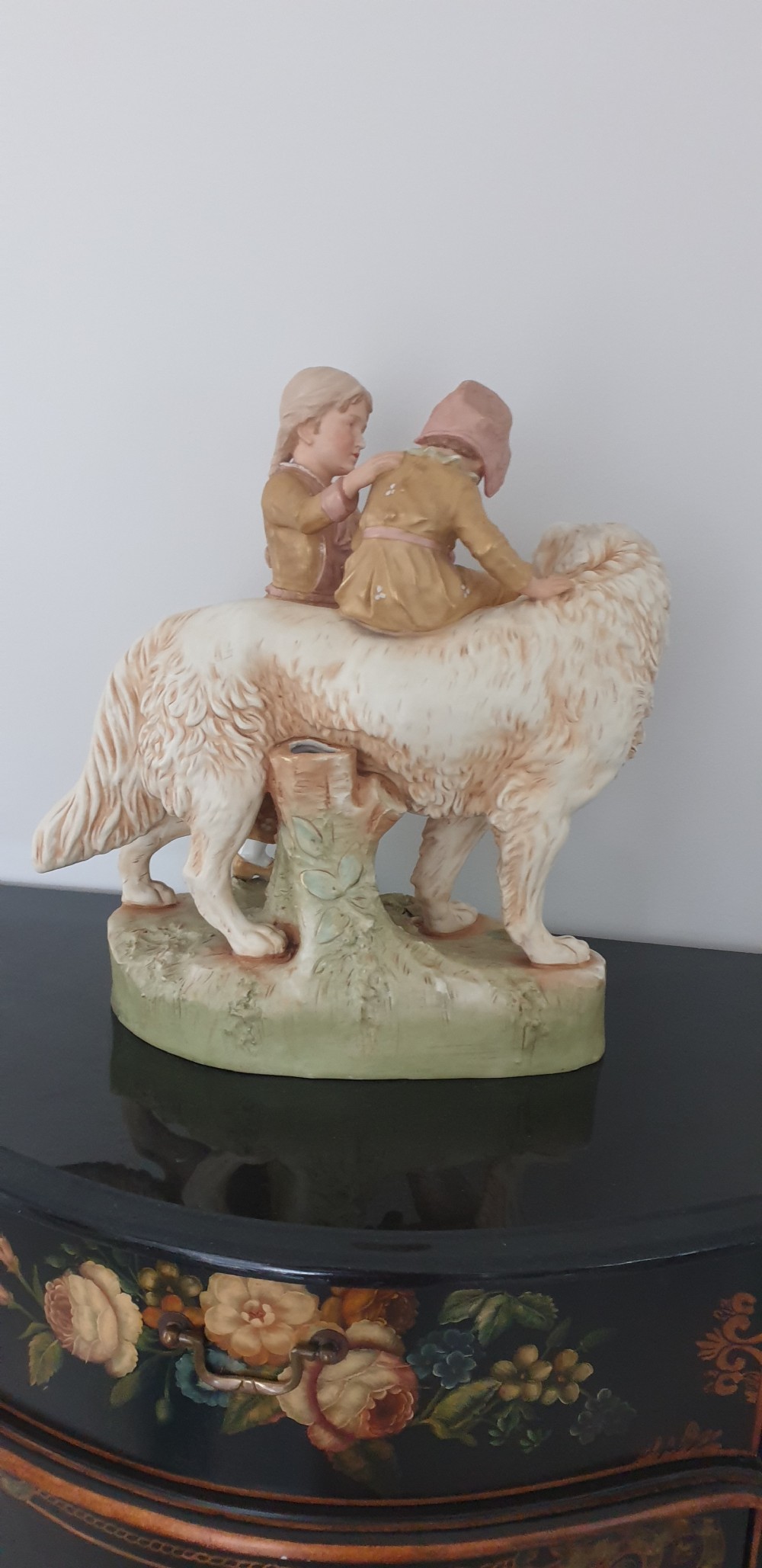 An antique Royal Dux porcelain figure group depicting two children interacting with a large dog on a green base. View V