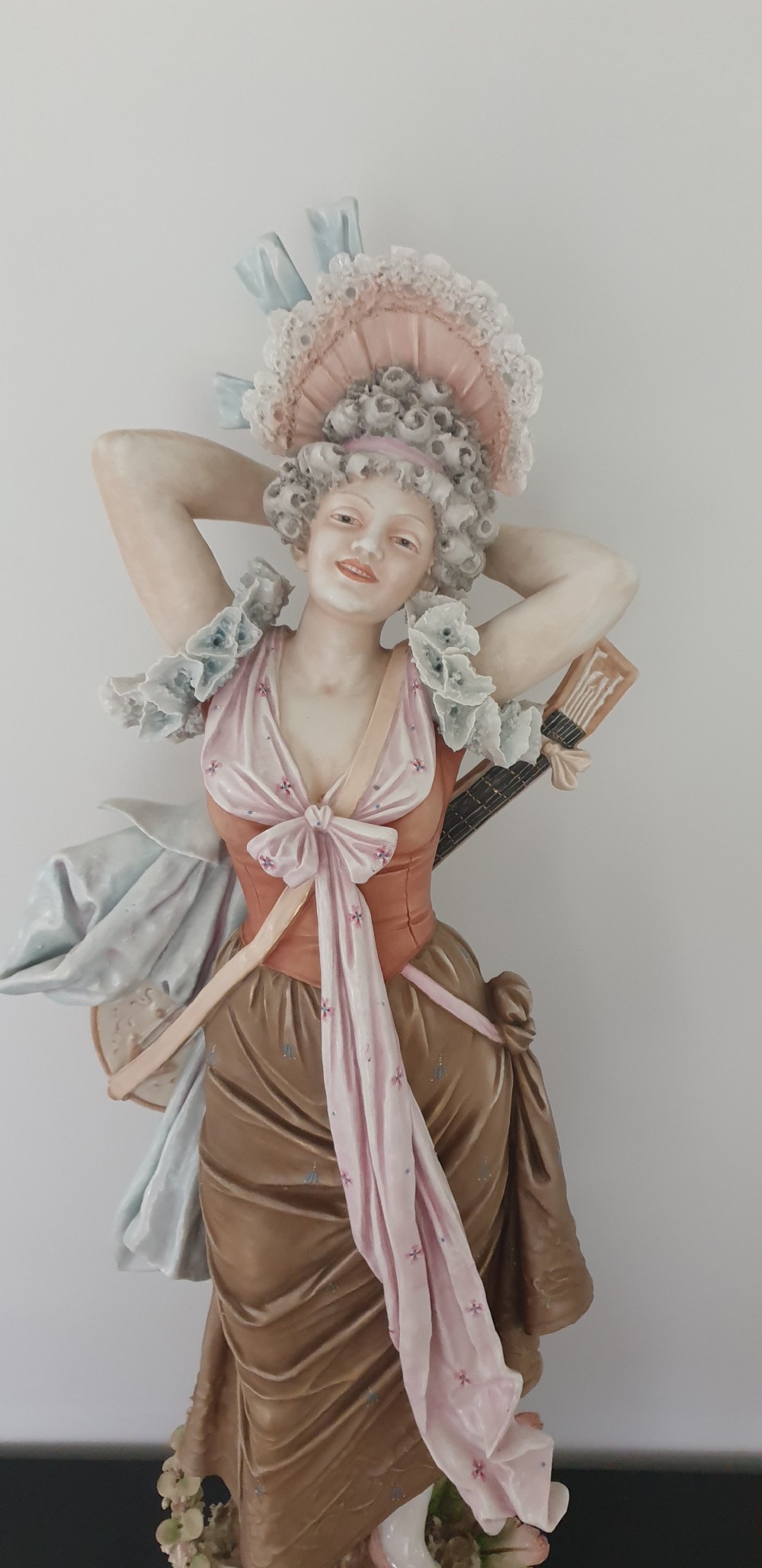 A tall Royal Dux porcelain figure of a lady in historical attire holding a musical instrument on an ornate base. View III