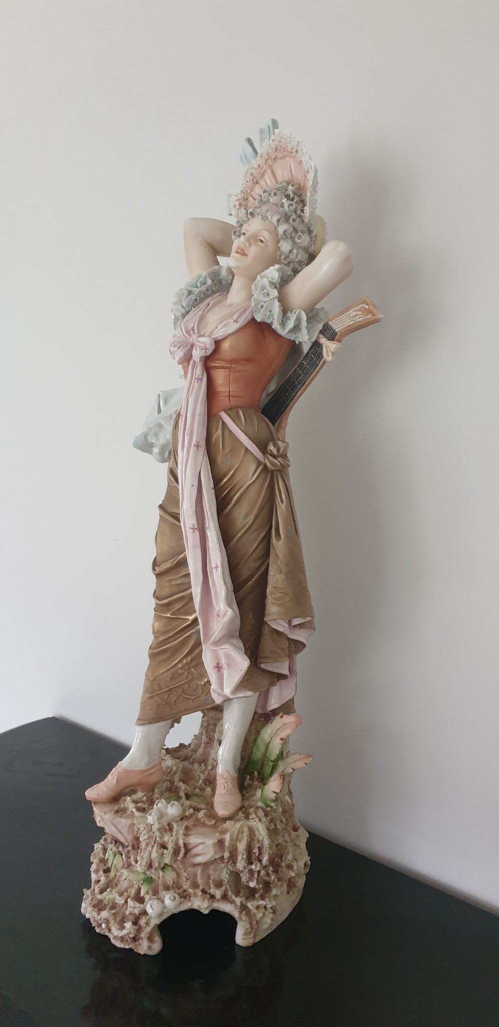 A tall Royal Dux porcelain figure of a lady in historical attire holding a musical instrument on an ornate base. View VI