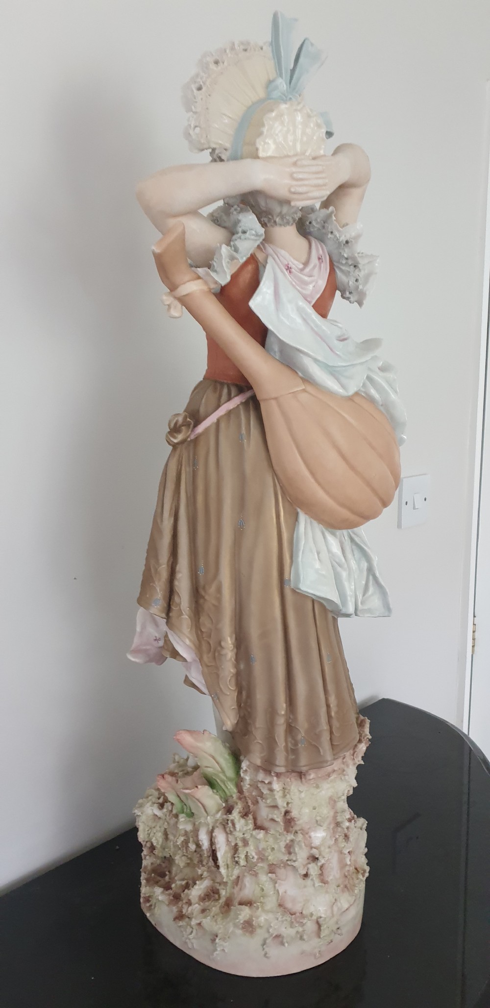 A tall Royal Dux porcelain figure of a lady in historical attire holding a musical instrument on an ornate base. View X