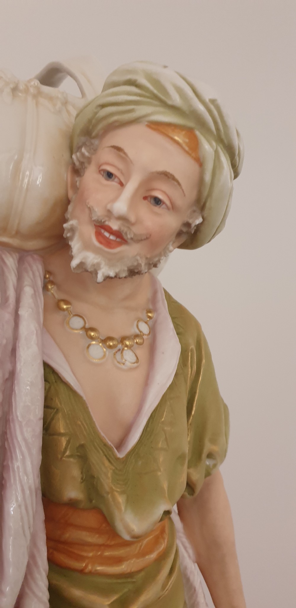 A pair of large antique Royal Dux porcelain figures depicting male and female water carriers in olive green and terracotta attire. View III