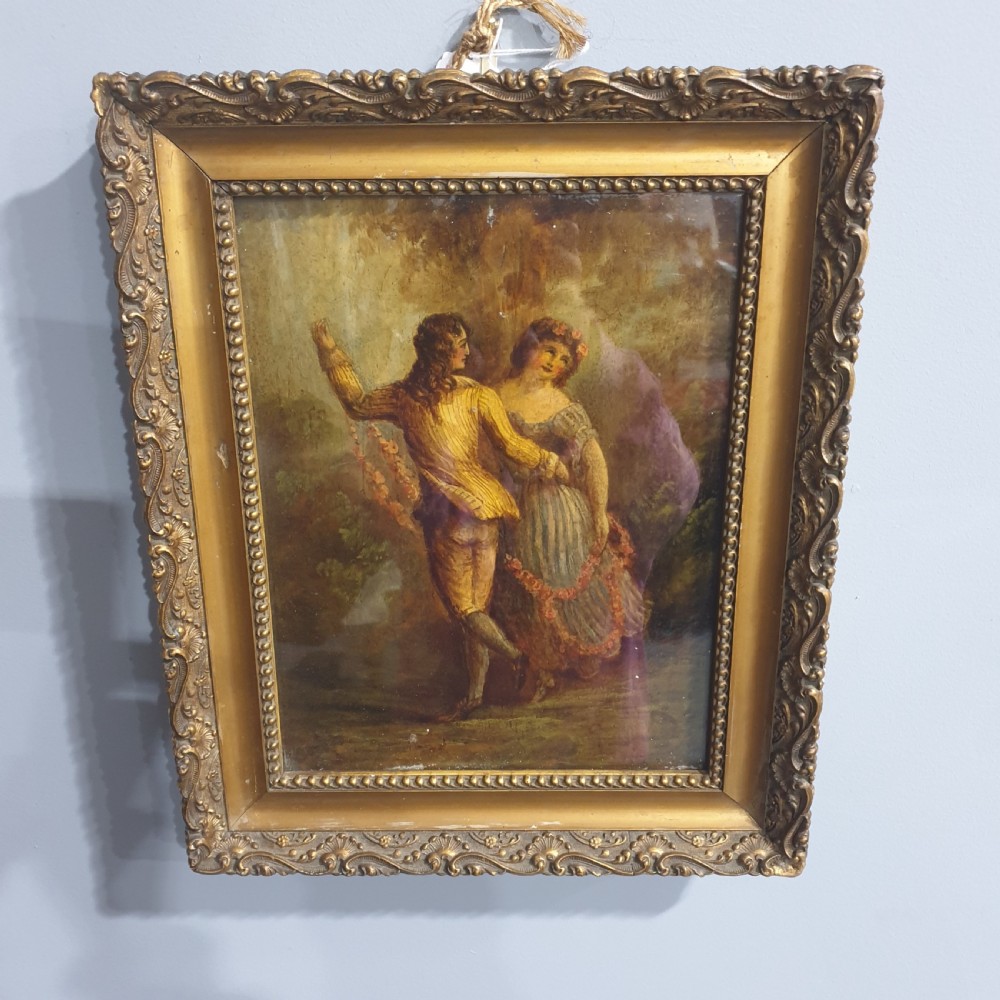 A nineteenth-century framed oil painting on board depicting a man and woman in historical costume dancing in a landscape setting, enclosed within an ornate carved gold frame.