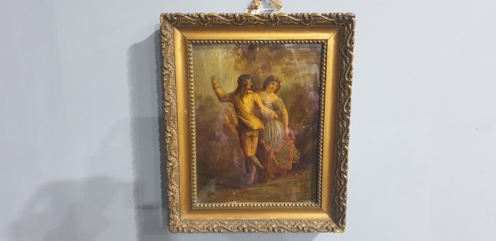 A nineteenth-century framed oil painting on board depicting a man and woman in historical costume dancing in a landscape setting, enclosed within an ornate carved gold frame. View II