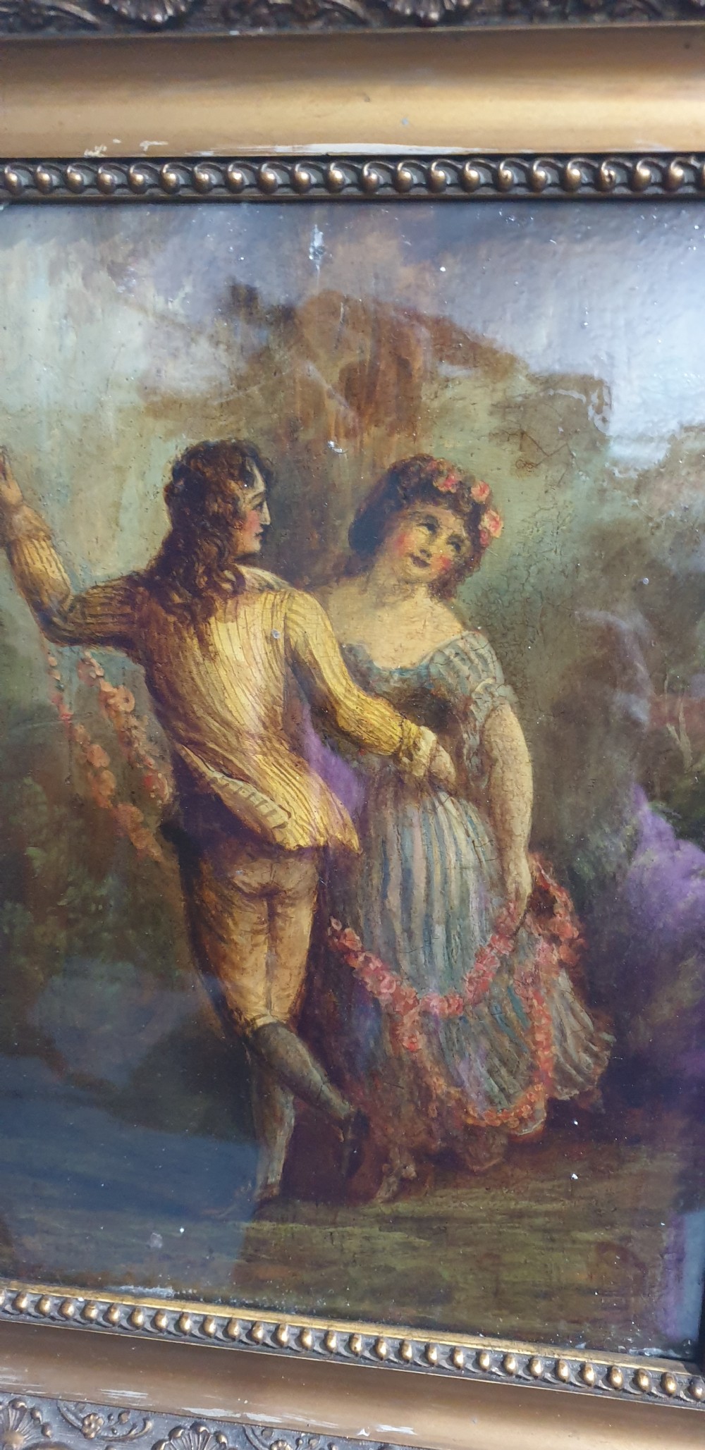A nineteenth-century framed oil painting on board depicting a man and woman in historical costume dancing in a landscape setting, enclosed within an ornate carved gold frame. View III