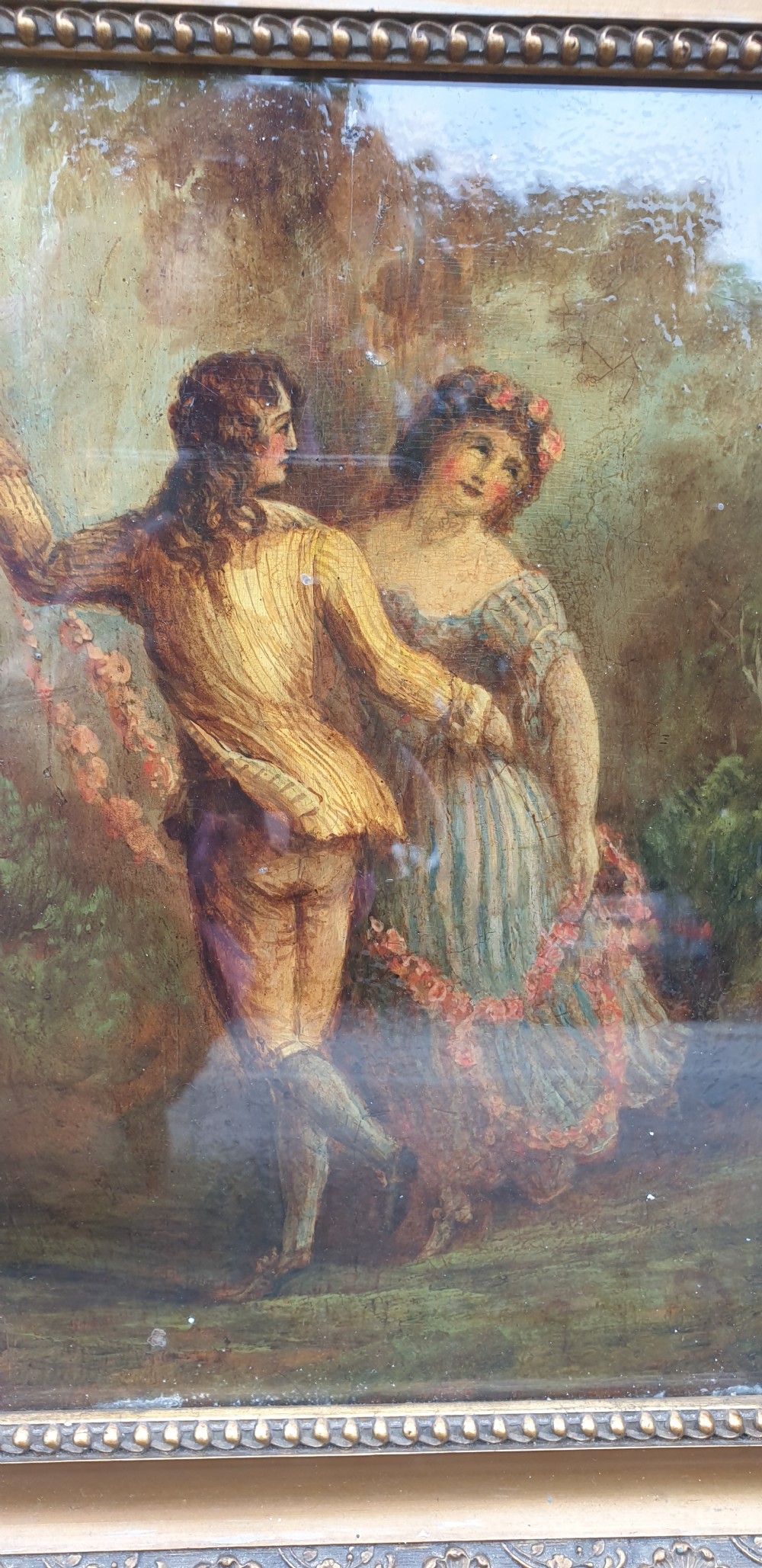 A nineteenth-century framed oil painting on board depicting a man and woman in historical costume dancing in a landscape setting, enclosed within an ornate carved gold frame. View IV