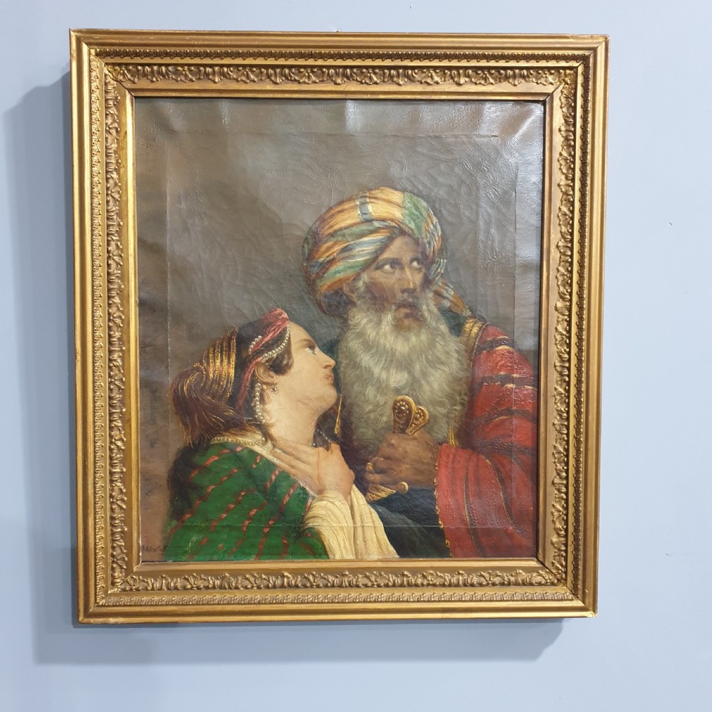 An antique framed oil painting on canvas depicting a bearded man in a turban alongside a woman looking upward.