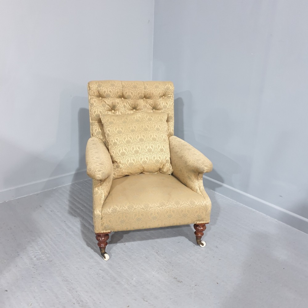 A Victorian library armchair upholstered in gold damask fabric featuring button-back tufting and turned mahogany legs with ceramic castors. View II
