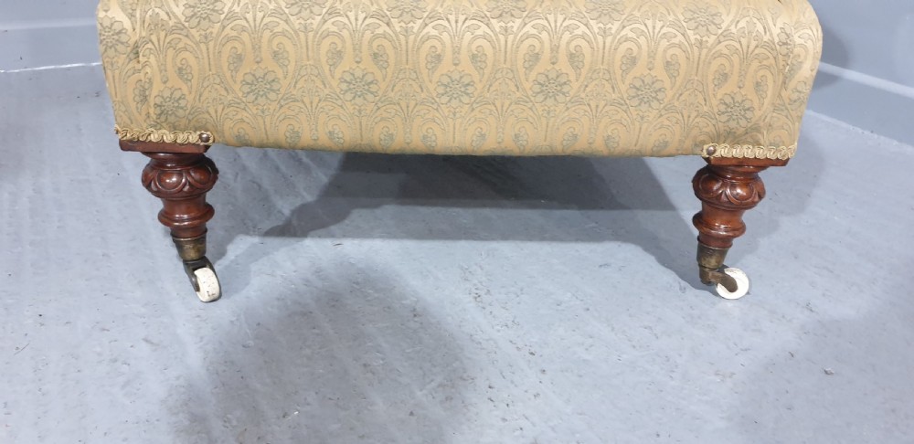 A Victorian library armchair upholstered in gold damask fabric featuring button-back tufting and turned mahogany legs with ceramic castors. View VI