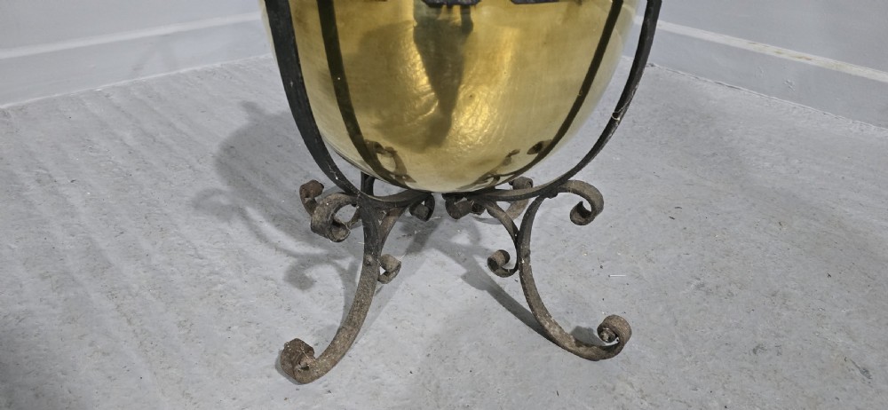 An Arts and Crafts coal bucket featuring a hemispherical brass bowl set within a wrought iron frame with scrolled feet and a spiral wire handle. View IV
