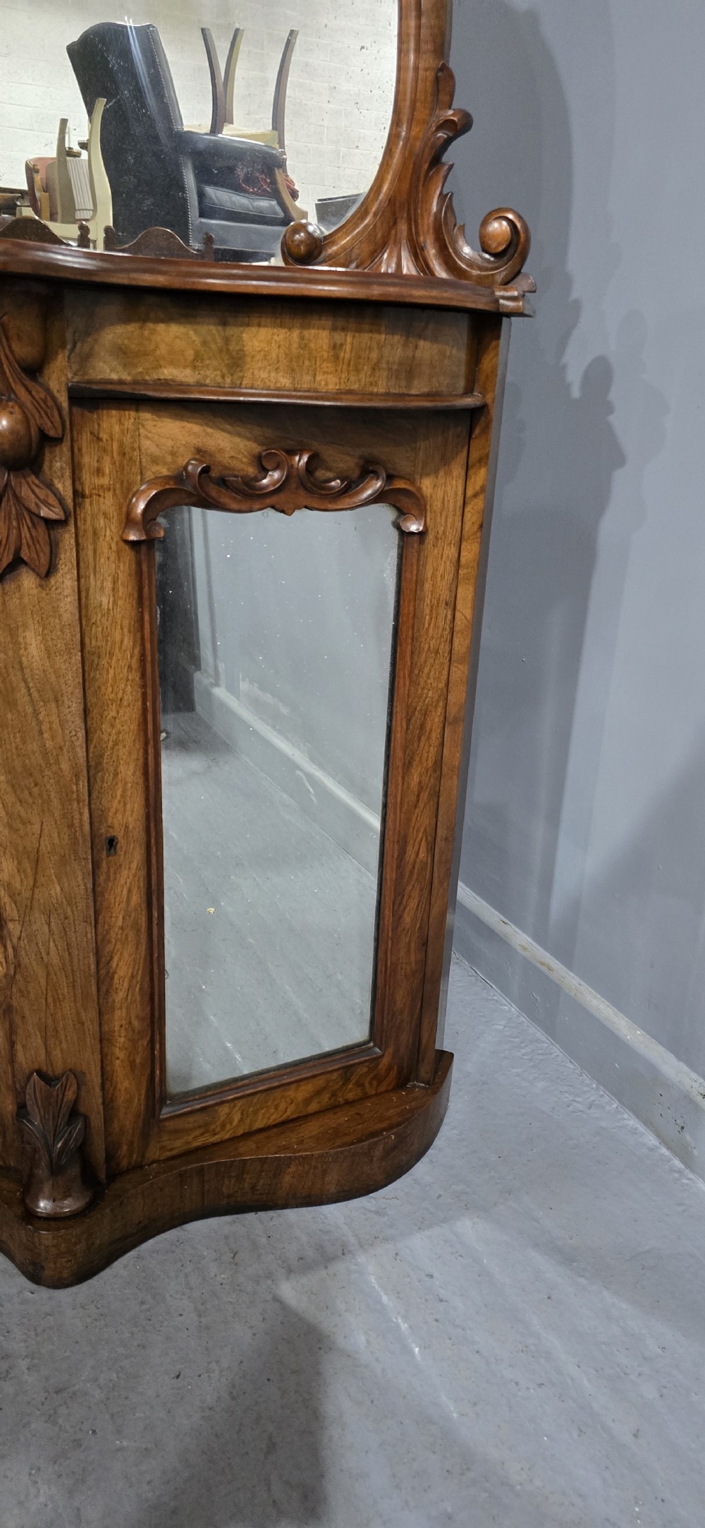 An antique burr walnut side cabinet featuring an arched top mirror with a carved cresting and glass mirrored door panels. View XIII