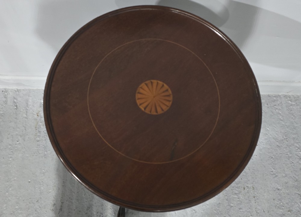 A round mahogany wine table featuring an inlaid central starburst motif, a turned column pedestal, and three splayed legs. View II