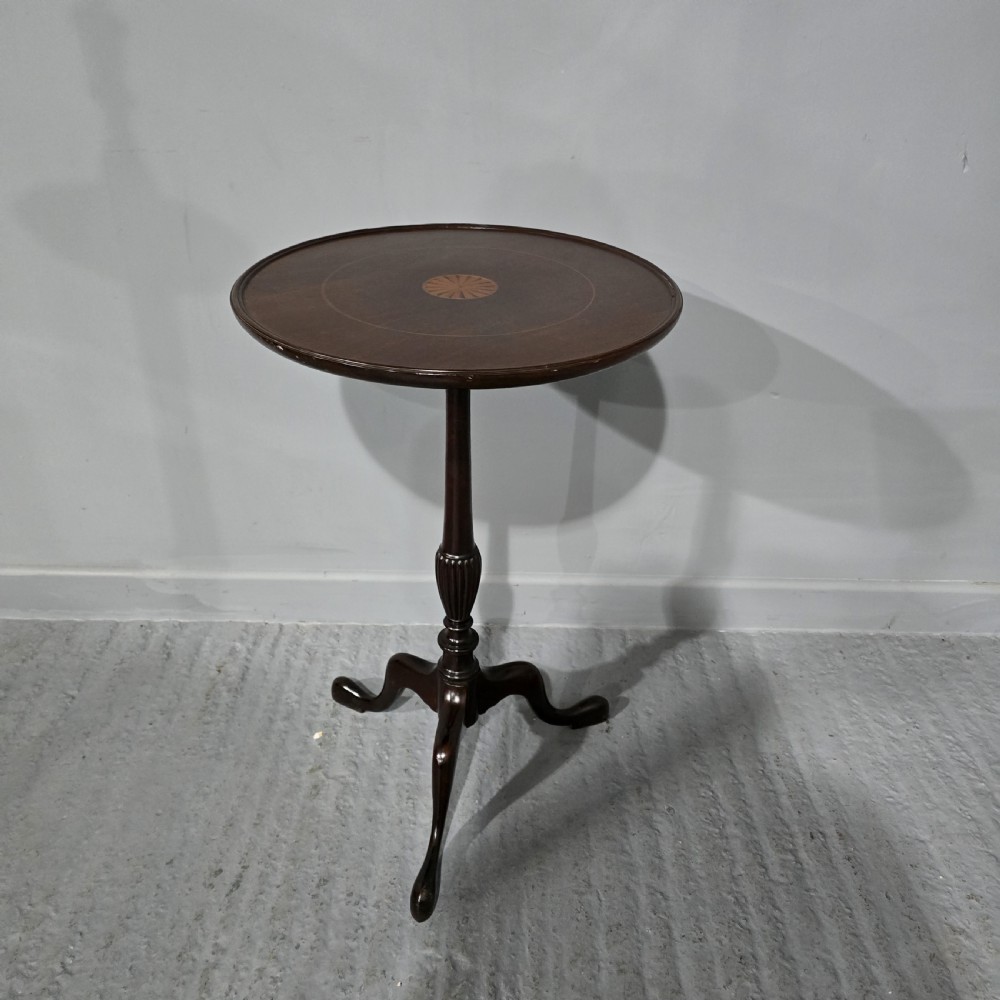 A round mahogany wine table featuring an inlaid central starburst motif, a turned column pedestal, and three splayed legs. View III