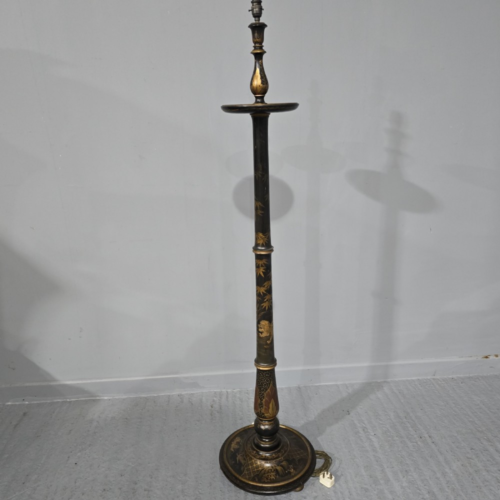 A black lacquered standard floor lamp decorated with gilded hand-painted Chinoiserie foliage and landscapes, topped with a cream fringed lampshade. View II