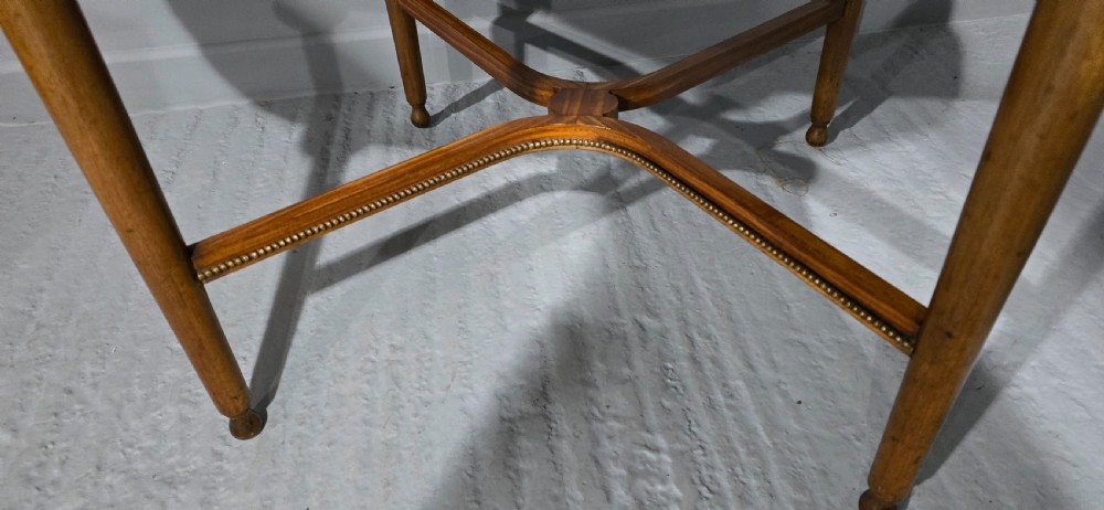An oval satinwood coffee table featuring a parquetry top, gilt egg-and-dart rim moulding, fluted tapered legs, and an X-frame stretcher. View V