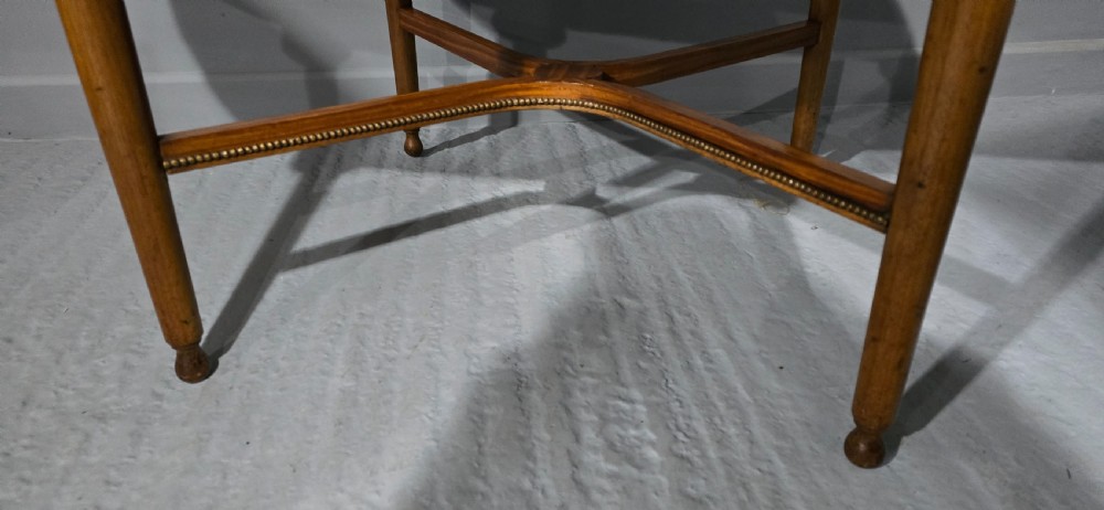 An oval satinwood coffee table featuring a parquetry top, gilt egg-and-dart rim moulding, fluted tapered legs, and an X-frame stretcher. View VI