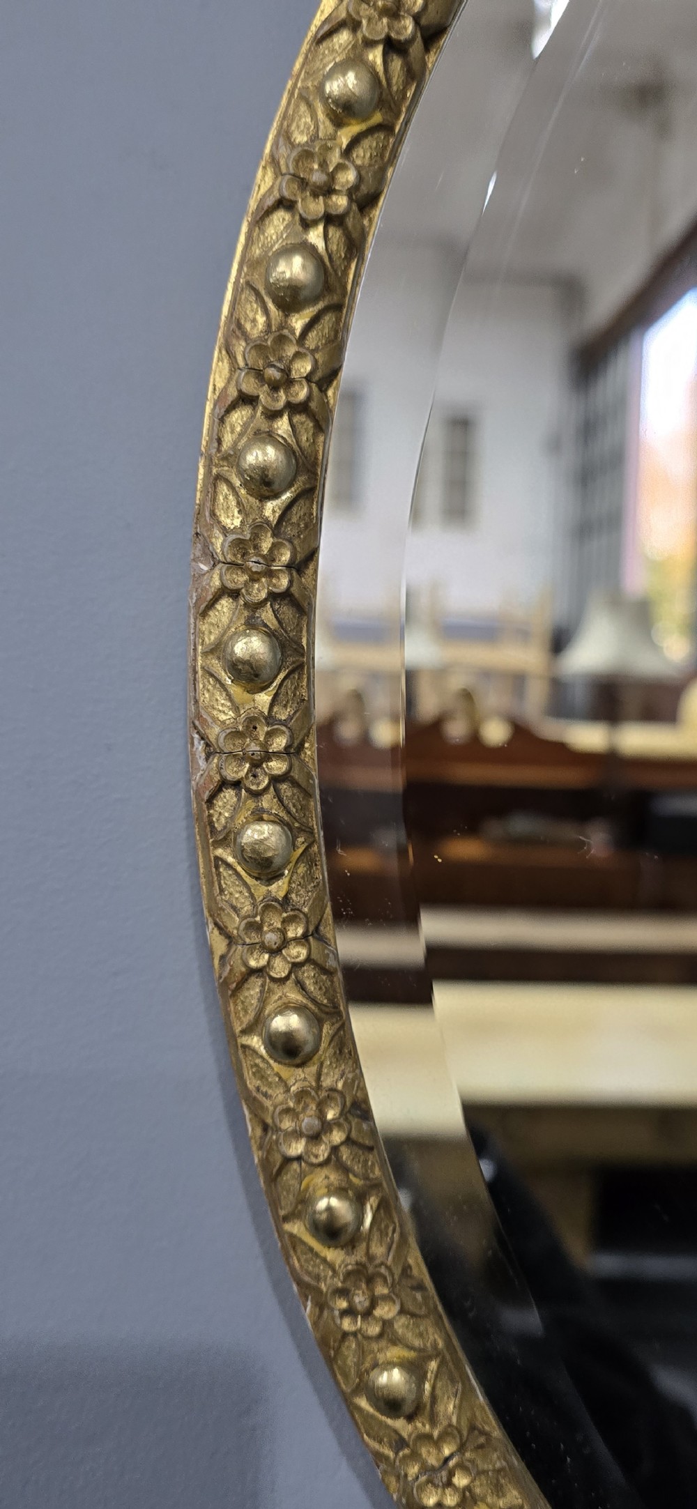 A pair of matching oval wall mirrors featuring molded gold gilt frames and bevelled glass plates. View VII
