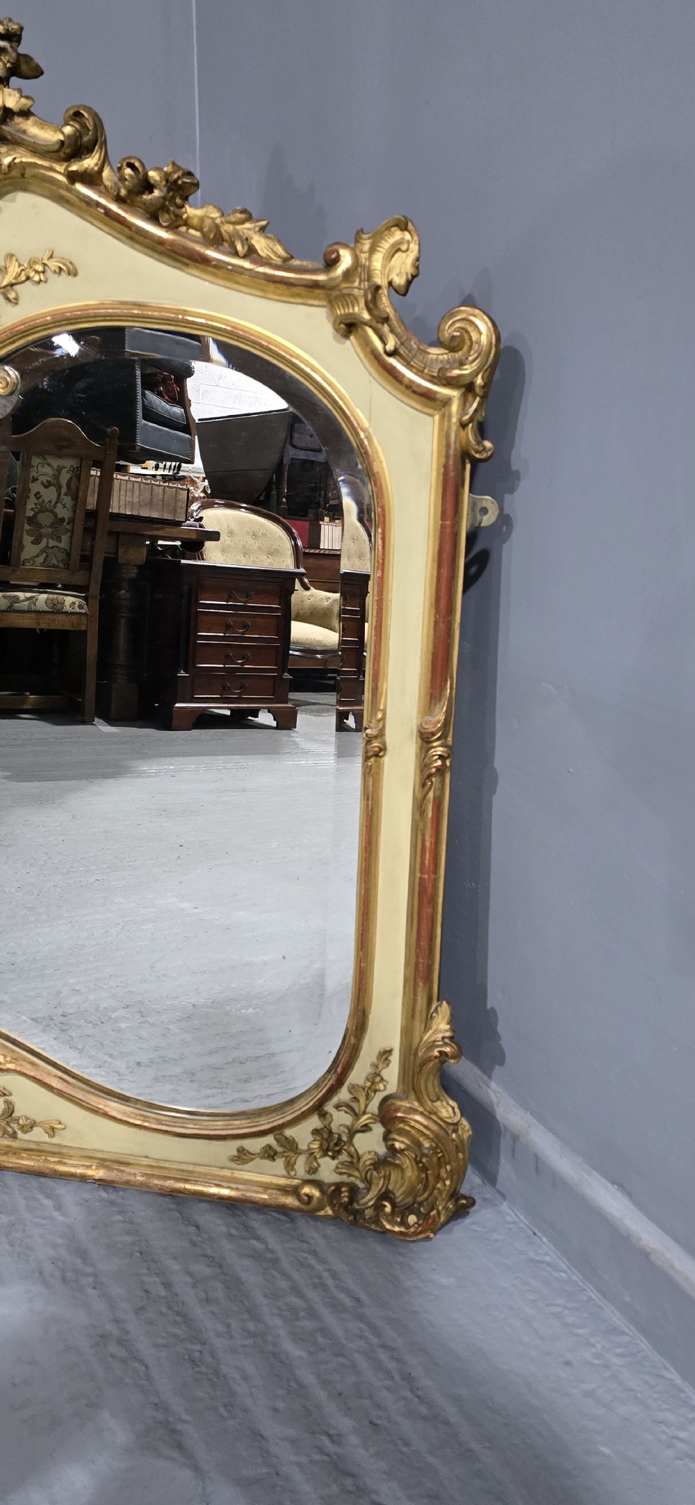 A large Victorian Rococo Revival giltwood and cream painted overmantel mirror featuring shell cresting, carved scrolls, and an arched glass plate. View IV