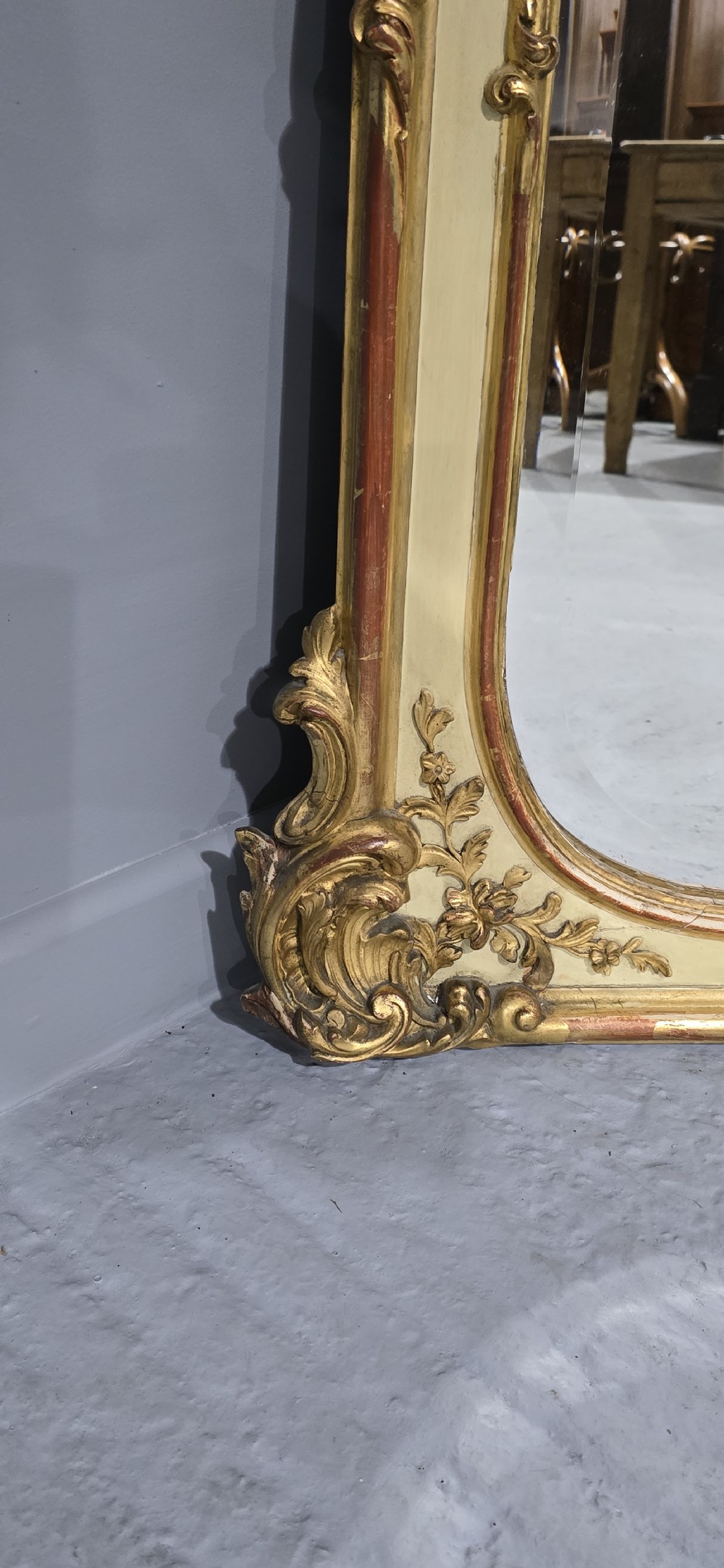 A large Victorian Rococo Revival giltwood and cream painted overmantel mirror featuring shell cresting, carved scrolls, and an arched glass plate. View VI