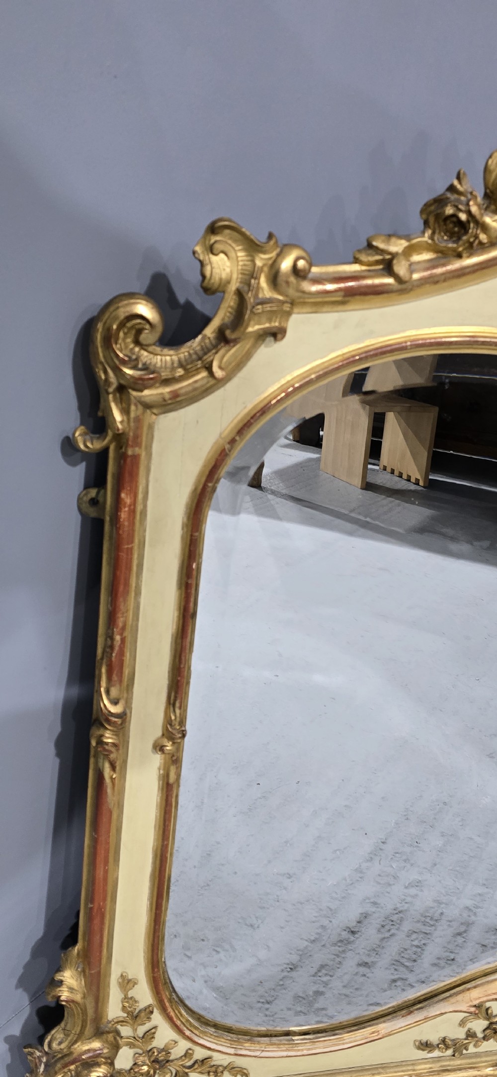 A large Victorian Rococo Revival giltwood and cream painted overmantel mirror featuring shell cresting, carved scrolls, and an arched glass plate. View VII