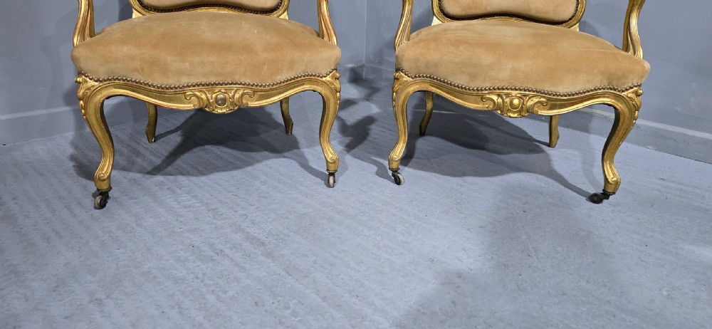 A pair of French giltwood bergere armchairs upholstered in mustard velvet with studded borders and cabriole legs. View II