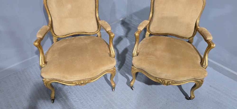 A pair of French giltwood bergere armchairs upholstered in mustard velvet with studded borders and cabriole legs. View III