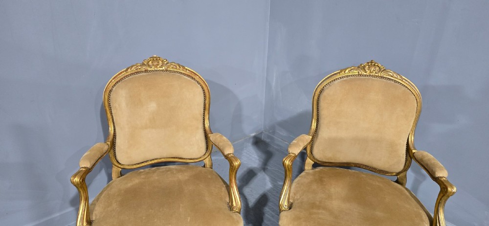 A pair of French giltwood bergere armchairs upholstered in mustard velvet with studded borders and cabriole legs. View IV