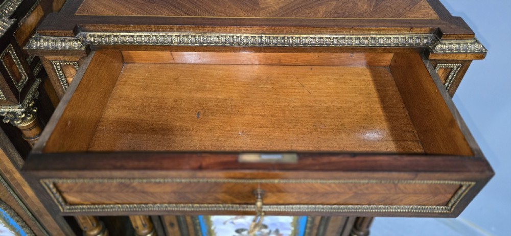 A pair of tall French Louis XVI style wooden side cabinets featuring parquetry veneers, fluted columns, gilt-bronze mounts, and central oval porcelain plaques painted with cherubs. View XIII