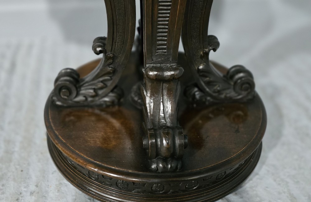 A Victorian dark carved timber side table with a circular black marble top featuring an inlaid floral pietra dura motif. View VII