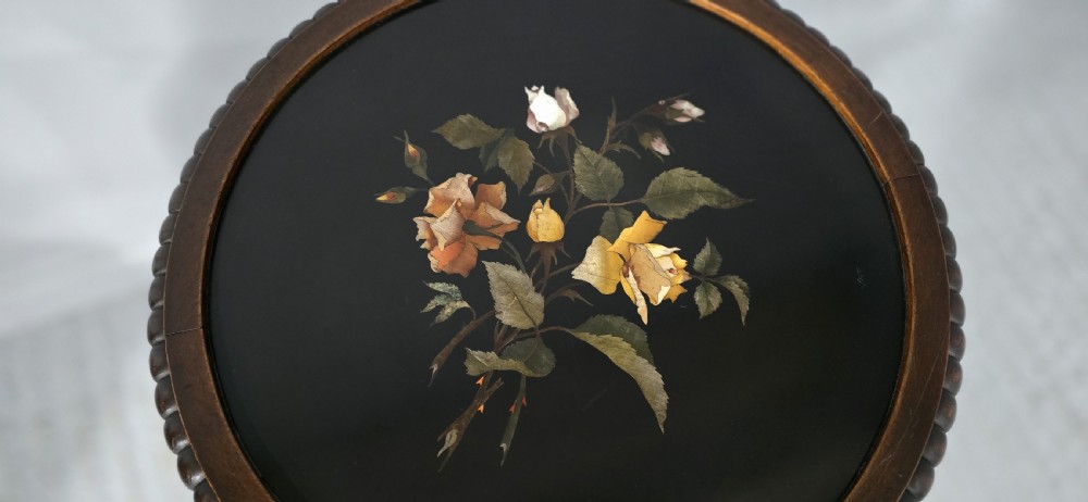 A Victorian dark carved timber side table with a circular black marble top featuring an inlaid floral pietra dura motif. View X