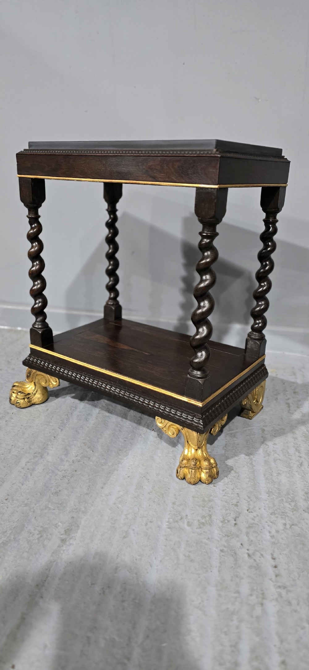 A rectangular dark rosewood two-tier side table featuring spiral turned legs, gilt borders, and carved gilded paw feet. View VI