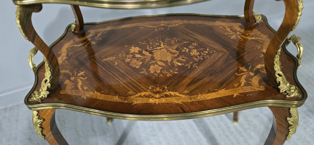 A two-tier French marquetry table featuring floral wood inlay, cabriole legs, and ornate gilt-bronze ormolu mounts. View III