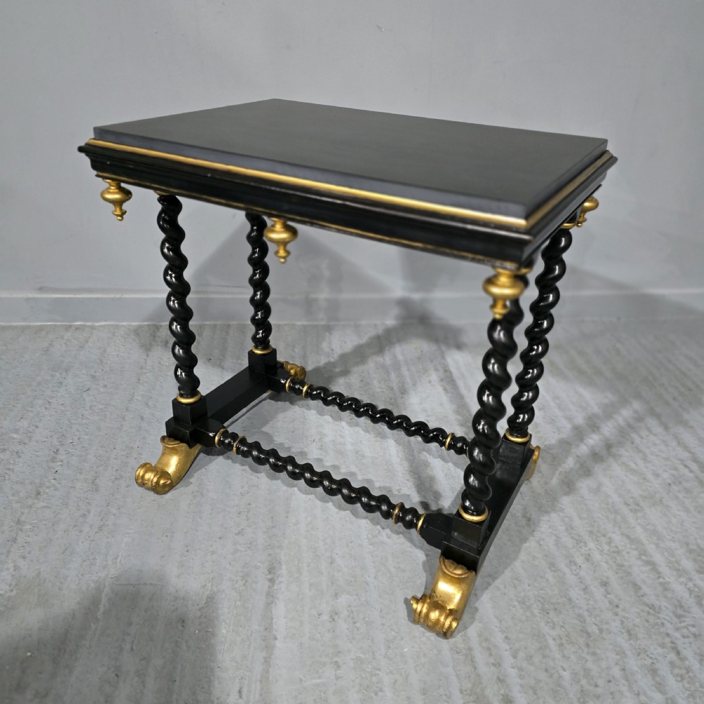 A rectangular ebonised black wood centre table featuring gold parcel gilded accents, spiral barley twist legs, drop finials, and an H-stretcher.