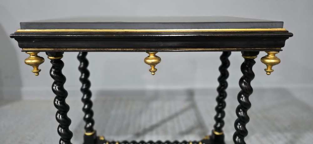 A rectangular ebonised black wood centre table featuring gold parcel gilded accents, spiral barley twist legs, drop finials, and an H-stretcher. View V
