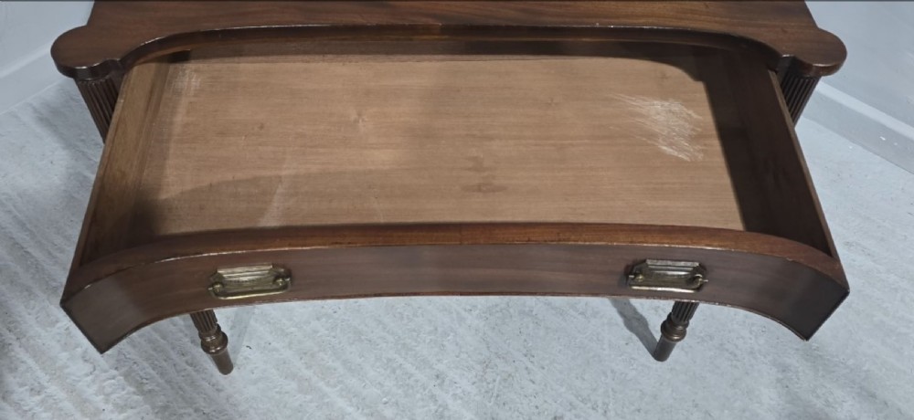 An antique Georgian mahogany side table featuring a single long drawer with brass handles and slender fluted tapered legs. View II