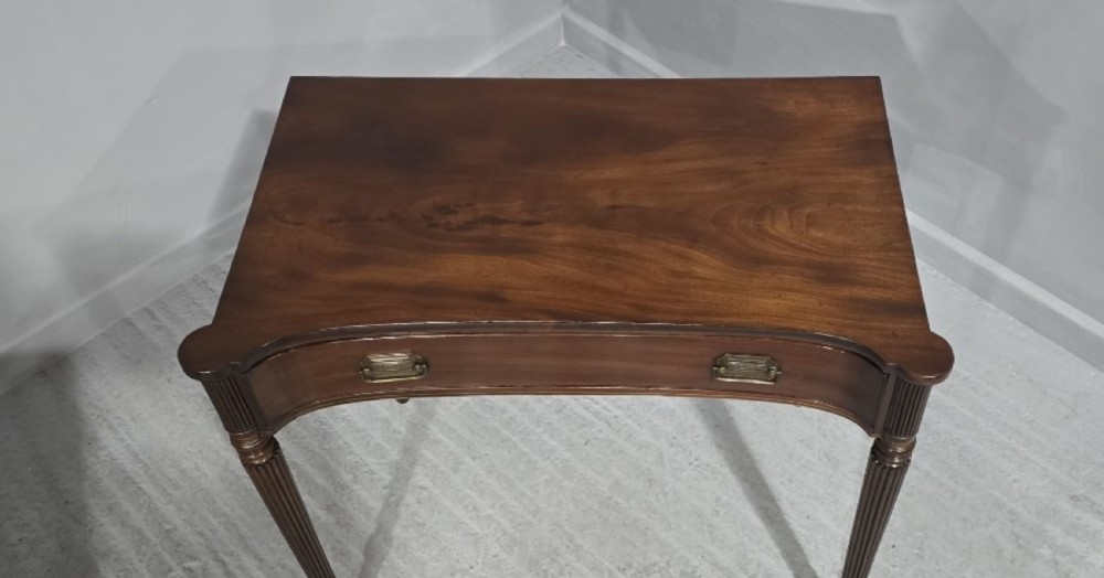 An antique Georgian mahogany side table featuring a single long drawer with brass handles and slender fluted tapered legs. View III