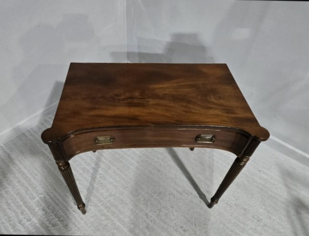 An antique Georgian mahogany side table featuring a single long drawer with brass handles and slender fluted tapered legs. View VI