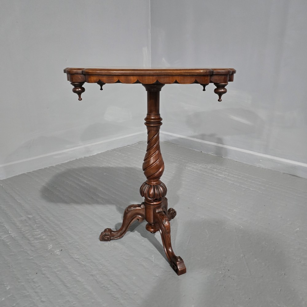 A Victorian mahogany pedestal table featuring a scalloped rim with turned pendant drops, a spiral carved central column, and tripod cabriole legs.