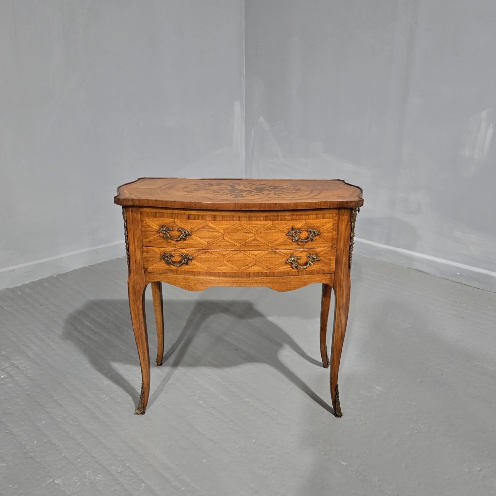A French Louis XV style marquetry side table with a serpentine top, floral wood inlays, two drawers with brass handles, and slender cabriole legs.