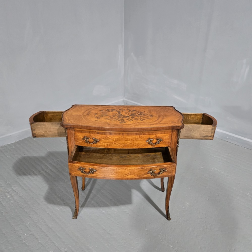 A French Louis XV style marquetry side table with a serpentine top, floral wood inlays, two drawers with brass handles, and slender cabriole legs. View II