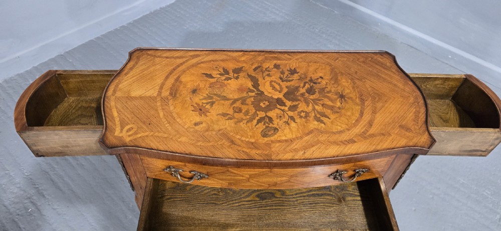 A French Louis XV style marquetry side table with a serpentine top, floral wood inlays, two drawers with brass handles, and slender cabriole legs. View III