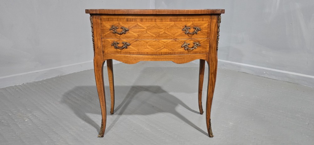 A French Louis XV style marquetry side table with a serpentine top, floral wood inlays, two drawers with brass handles, and slender cabriole legs. View VI