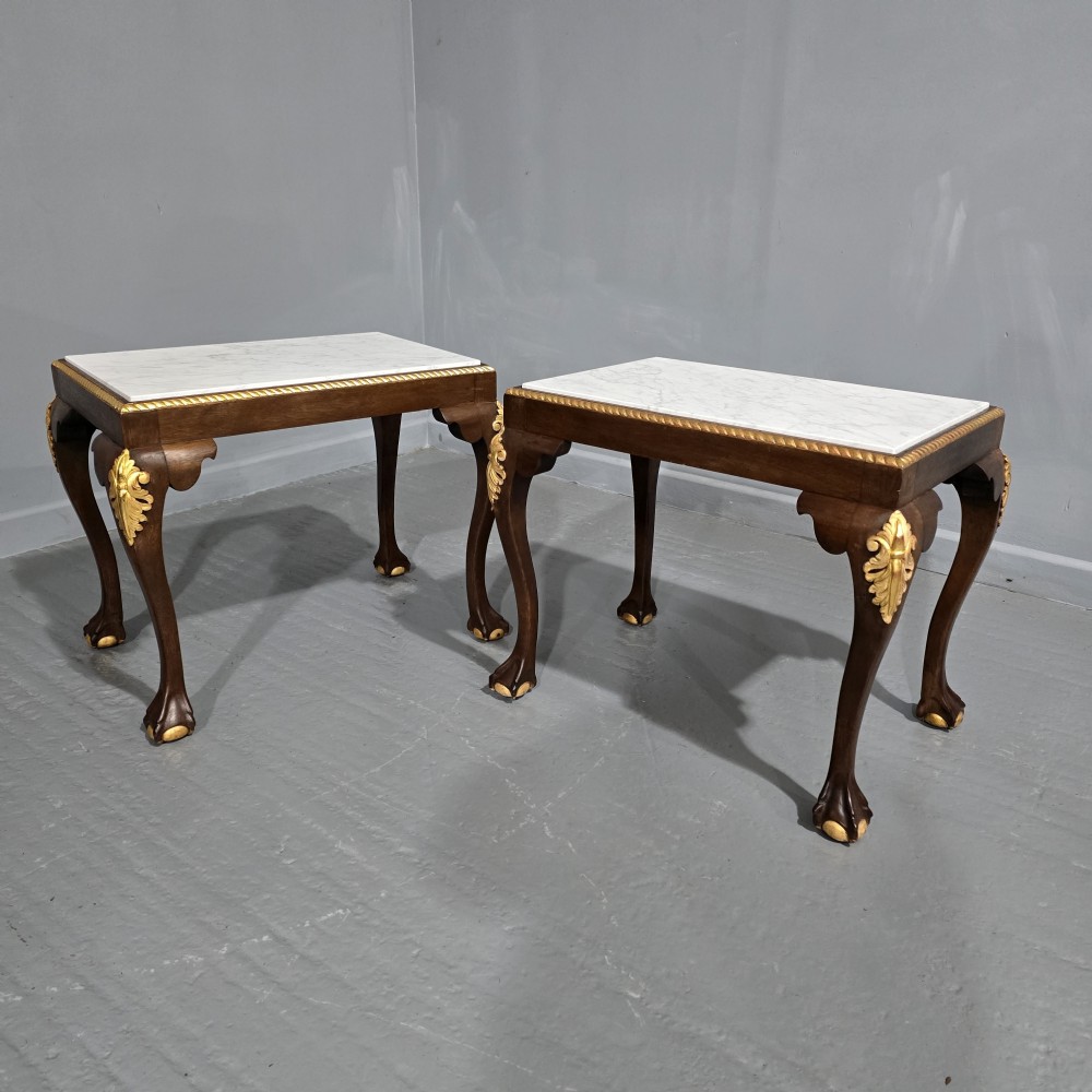 A pair of rectangular dark mahogany lamp tables featuring white marble inset tops, gilded acanthus leaf carvings, and carved cabriole legs with ball and claw feet.