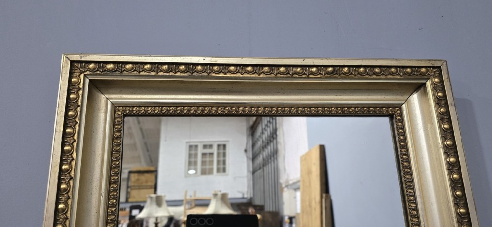 A matching pair of rectangular Victorian giltwood wall mirrors featuring beaded inner and outer frame details. View VI