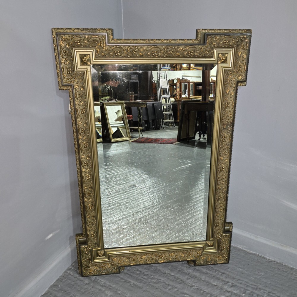 A large rectangular French giltwood wall mirror featuring elaborate carved corner mouldings and bevelled glass. View III