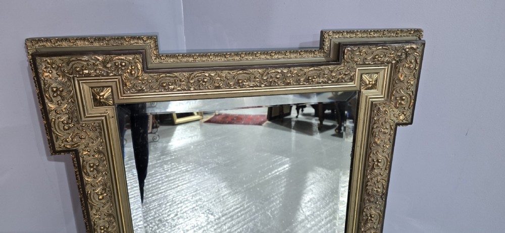 A large rectangular French giltwood wall mirror featuring elaborate carved corner mouldings and bevelled glass. View V